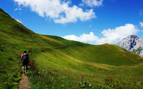 Members of the seminar hiking the green mountains during a sunny day.